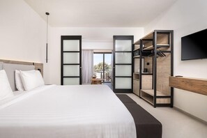 Une chambre d’hôtel moderne avec un grand lit, un téléviseur fixé au mur et une porte de placard coulissante.
