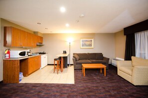 A compact living space with a kitchenette, a sofa, a dining area, and a patterned carpet. - Ottawa Kanata Hotel and Conference Centre (Ottawa)