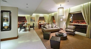 A spacious living room with a sofa, armchairs, a dining table, and a large window with a city view. - The Tower Plaza Hotel Dubai (Dubai)