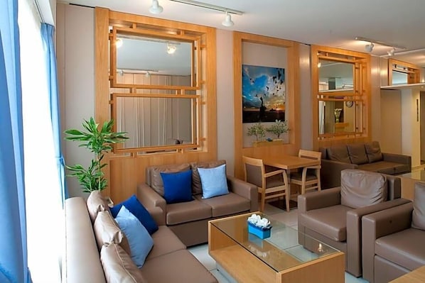 A modern living room with a sofa, coffee table, and a painting on the wall.