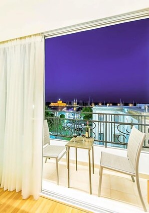 A balcony with a view of a marina at night.