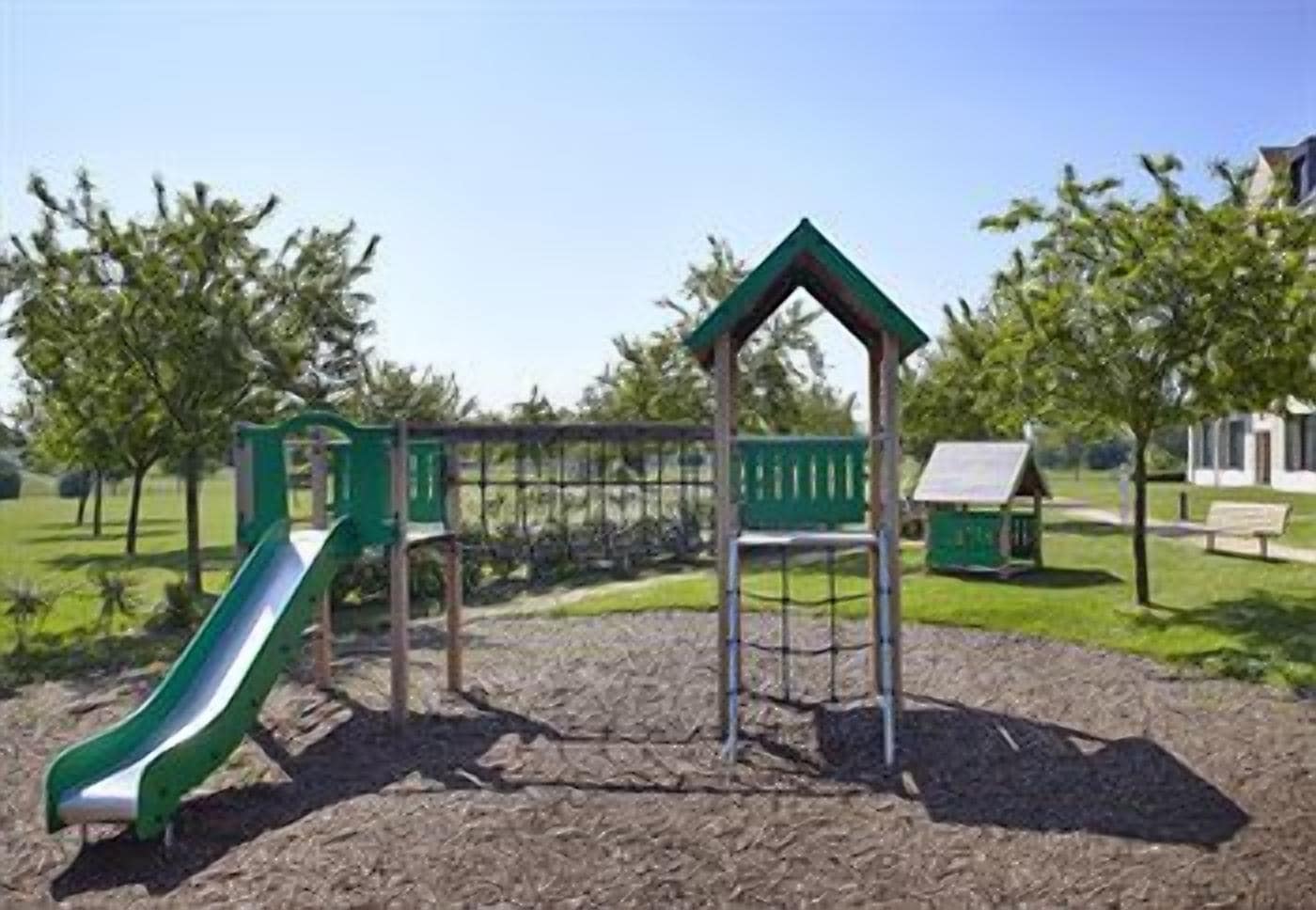 Une aire de jeux avec un toboggan et des structures d’escalade.