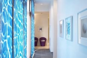 A hallway with a patterned wall, a door, and a framed picture on the wall. - Crowne Plaza Paris Marne-la-vallée by IHG (Magny-le-Hongre)