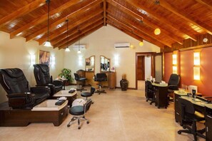 A spacious room with a high ceiling, a massage chair, a desk, and a computer. - The Club Barbados Resort & Spa - Adults Only (Holetown)