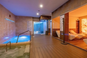 Ein Wellnessbereich mit Whirlpool, Holzböden und Liegestühlen.