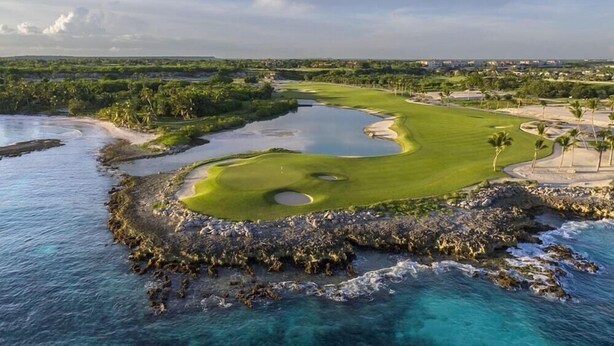 A coastal golf course with a water hazard, a sand bunker, and a clear view of the ocean. - TAN Resorts Marina Cap Cana (Punta Cana)
