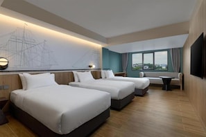 Une chambre d’hôtel avec deux lits, une grande fenêtre, un téléviseur à écran plat et une œuvre d’art accrochée au mur.