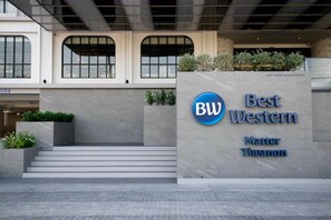 L’entrée d’un immeuble, avec une enseigne indiquant « Best Western Matter Tiwanon ».