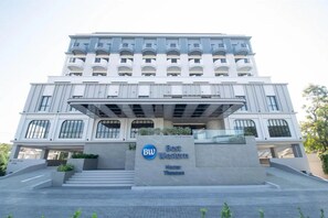 Ein modernes Gebäude mit einem markanten Eingang, einem Schild für 'Best Western Hotel Thuan Son' und einer Reihe von Fenstern an der Fassade.