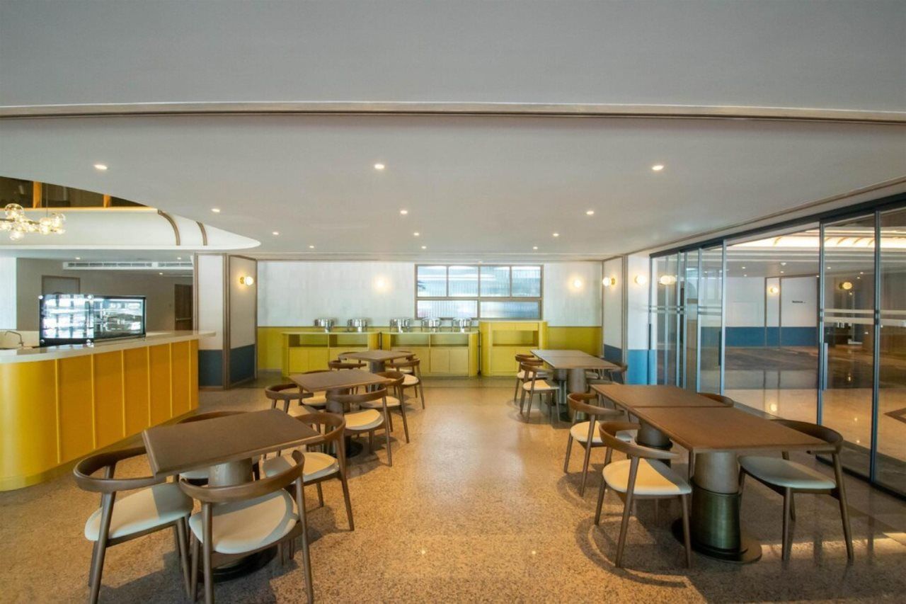 A modern dining area with a counter, tables, and chairs.