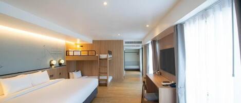 Habitación de hotel con cama, escritorio y vistas de la ciudad.