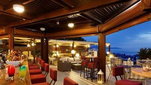An outdoor bar area with seating and a view of the sea. - Indigo Mare (Platanias)