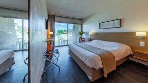 A hotel room with a bed, a desk, a chair, and a view of the outdoors. - Noemys Toulon La Valette (La Valette-du-Var)