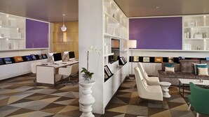 Un moderno vestíbulo de hotel con mostrador de recepción, zona de estar y suelo estampado.