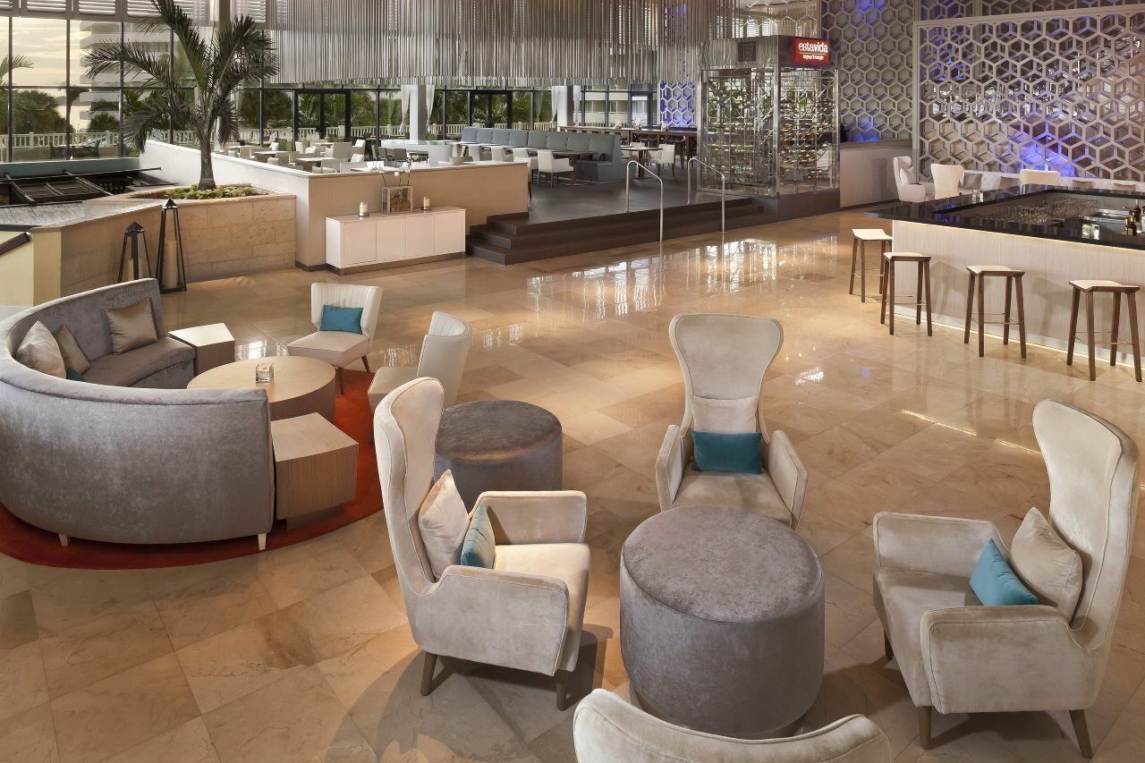 Un moderno hall de hotel con zona de estar, un bar y vistas al exterior.