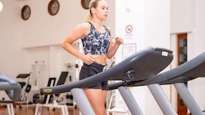 Un gimnasio con cintas de correr y equipo de ejercicio.