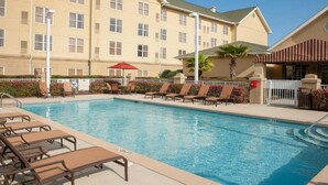 A hotel with a swimming pool, sun loungers, and a covered area. - Homewood Suites by Hilton Pensacola Arpt (Pensacola)