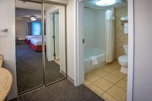 Ein Hotelzimmer mit Bett, Badezimmer mit Badewanne und Toilette.