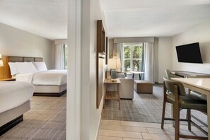 A hotel room with a bed, a desk, a chair, a TV, and a window with curtains. - Homewood Suites by Hilton Pensacola Arpt (Pensacola)