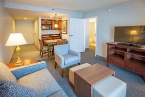 A hotel room with a living area, a dining area, and a kitchenette. - Homewood Suites by Hilton Pensacola Arpt (Pensacola)