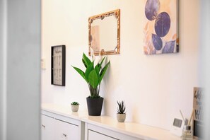 A white wall with a mirror, a welcome sign, and a framed picture. - Ssalford Spacious 4BR House Sleeps 7 + Garden (Greater Manchester)