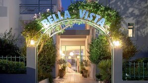 Entrada de hotel con un letrero que dice 'RELLA VISTA' y un camino que conduce a la puerta.