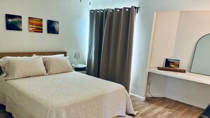 Una camera da letto con un letto, un comodino, una lampada, una scrivania, una sedia, una finestra con tende e decorazioni alle pareti.