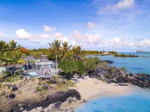 A tropical resort with a beach, clear blue waters, and palm trees. - LUX Grand Gaube Resort and Villa (Grand Gaube)