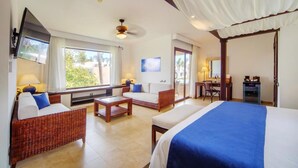 A hotel room with a bed, a sofa, a desk, and a television. - Portblue Le Sivory Boutique Hotel (Punta Cana)