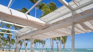 A beachside lounge with white furniture and a view of the ocean. - Portblue Le Sivory Boutique Hotel (Punta Cana)