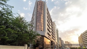 A modern building with a curved facade, multiple floors, and a prominent entrance.