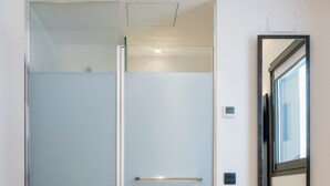 A modern bathroom with a glass shower enclosure, a visible toilet, and a mirror with a dark frame. - Madrid Centro Atocha (Madrid)