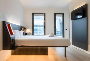 A modern hotel room with a bed, bedside tables, a flat-screen TV, and large windows. - Madrid Centro Atocha (Madrid)