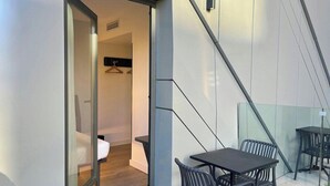 A modern interior with a glass partition, a table with chairs, and a hanging coat rack. - Madrid Centro Atocha (Madrid)