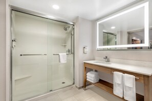A modern bathroom with a glass-enclosed shower, a wooden vanity with a sink, and a large mirror. - Sleep Inn & Suites BWI Airport (Baltimore)