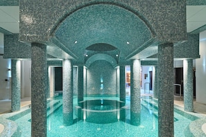 A large indoor pool with a mosaic ceiling and columns, surrounded by a tiled floor. - St. George Beach Hotel & Spa Resort - Adults Only (Chlorakas)