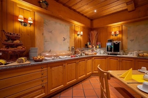 Ein Holzinterieur mit Frühstückstresen, Buffet und Kaffeemaschine.