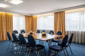 Ein Konferenzraum mit einem langen Tisch, Stühlen und einem Büfett.