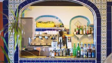 A bar area with a tiled backsplash and a mirror reflecting the interior.