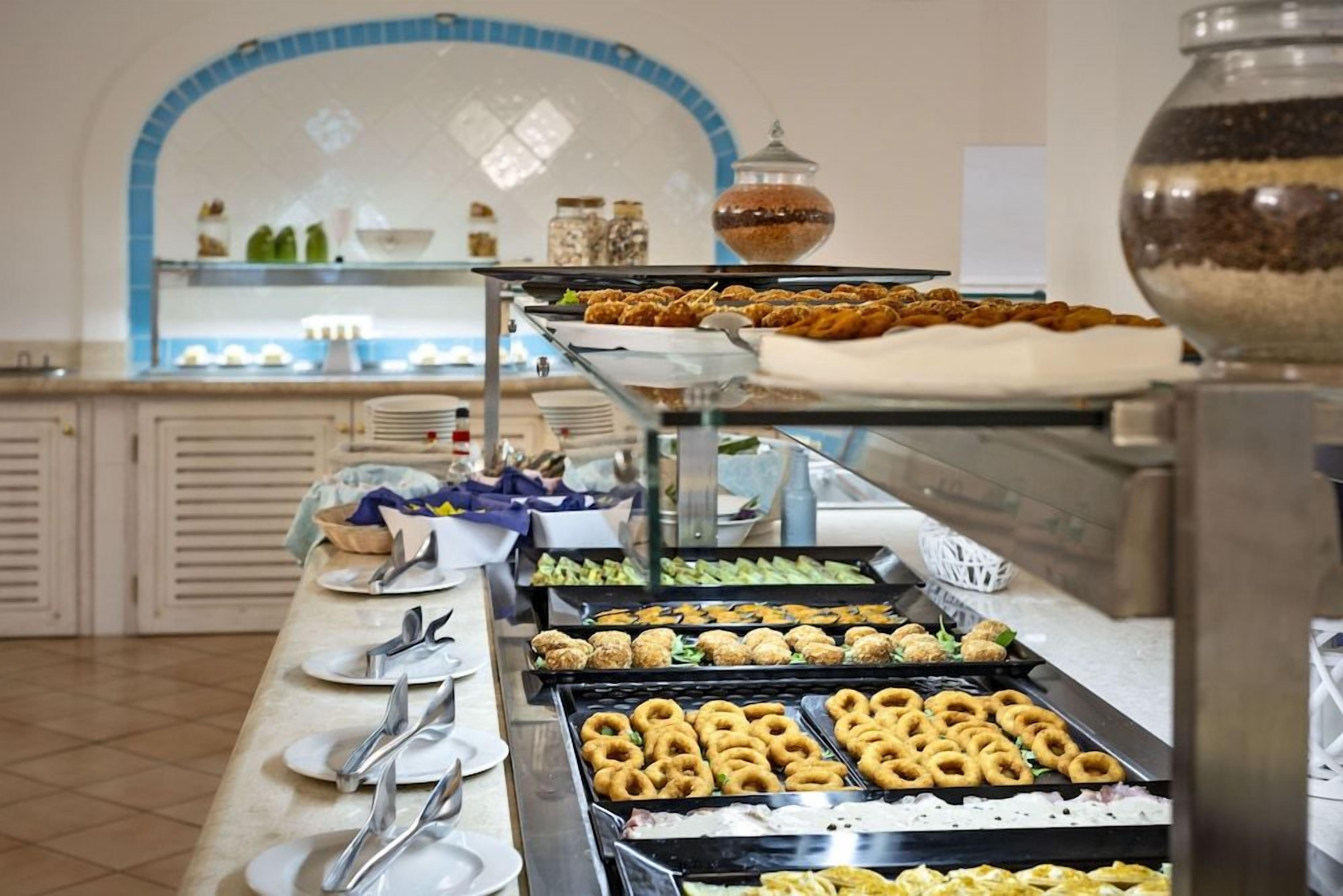 A buffet with various food items and utensils.