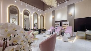 A modern interior with arched mirrors, a pink armchair, and a salon area. - Khalidia Palace Hotel Dubai (Dubai)