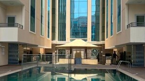 A modern hotel interior with a central pool, large windows, and a glass facade. - Khalidia Palace Hotel Dubai (Dubai)