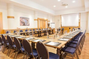 A conference room with long tables, chairs, a projector screen, and a clock on the wall. - Hotel Progress (Brussels)