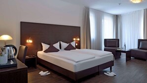 A hotel room with a large bed, a TV, a desk with a lamp, and a coffee maker. - Premier Inn Berlin City Spittelmarkt (Berlin)