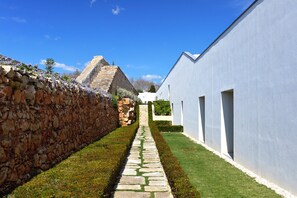 Un sentiero in pietra conduce a un edificio bianco, con una piramide sullo sfondo.