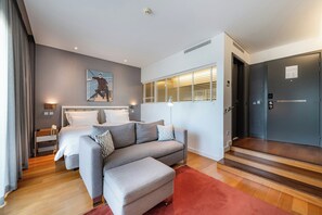 A modern hotel room with a bed, sofa, and a red carpet. - Pestana Cidadela Cascais (Cascais)