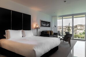Un dormitorio moderno con una cama grande, un sofá y una silla.