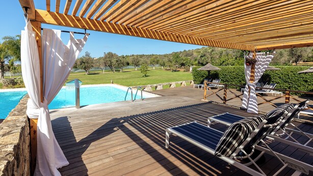 A wooden deck with a pool, lounge chairs, and a pergola providing shade. - Vila Valverde Design and Country Hotel (Lagos)