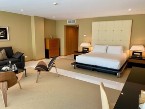 A hotel room with a large bed, a sofa, a desk, and a cabinet. - Vila Valverde Design and Country Hotel (Lagos)
