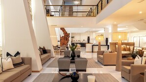 A spacious, multi-level hotel lobby with a high ceiling, a central seating area, and a reception desk. - Vila Valverde Design and Country Hotel (Lagos)